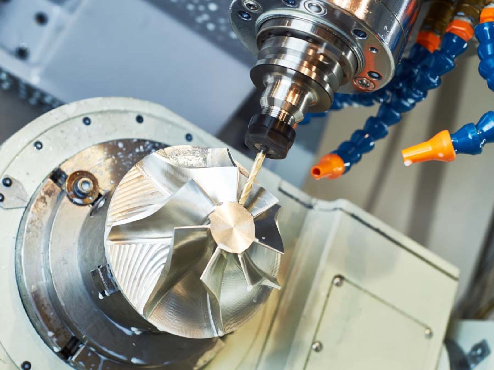 Five-axis CNC machine cutting a turbine impeller